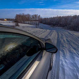 Car driving along a snow covered road